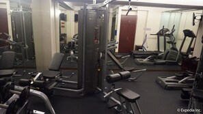 A gym with various exercise equipment including treadmills, weight machines, and dumbbells. - Ace Hotel & Suites (Pasig)