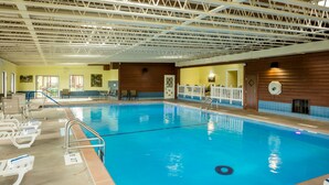 Ein Hallenbad mit deutlichen Fahrstreifenmarkierungen, einem Sprungbrett und einem Rettungsschwimmerstuhl.