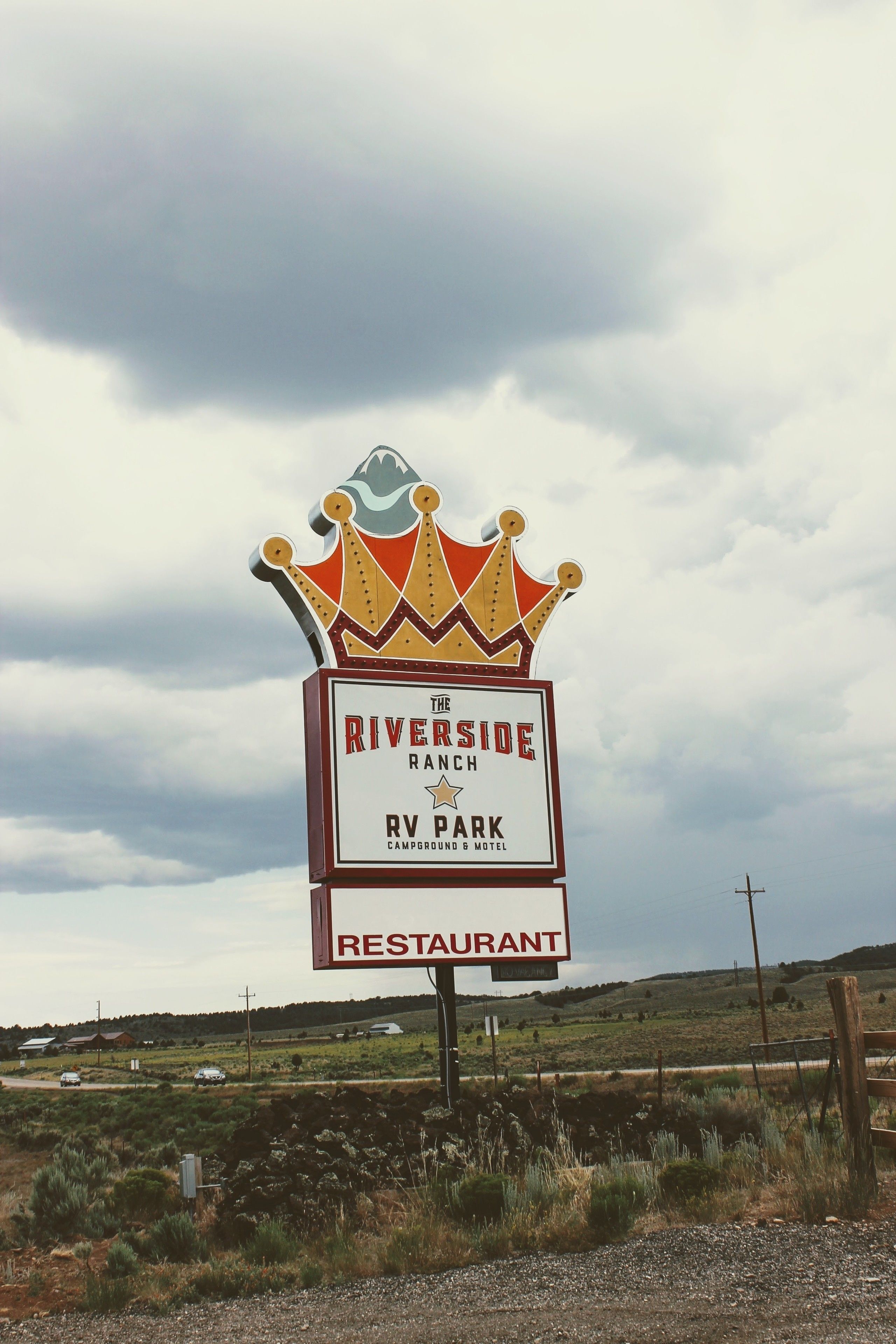 A sign for Riverside Ranch RV Park and Restaurant with a crown emblem.