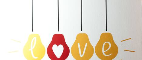 Four hanging light bulbs with the word "love" spelled out in different colors.