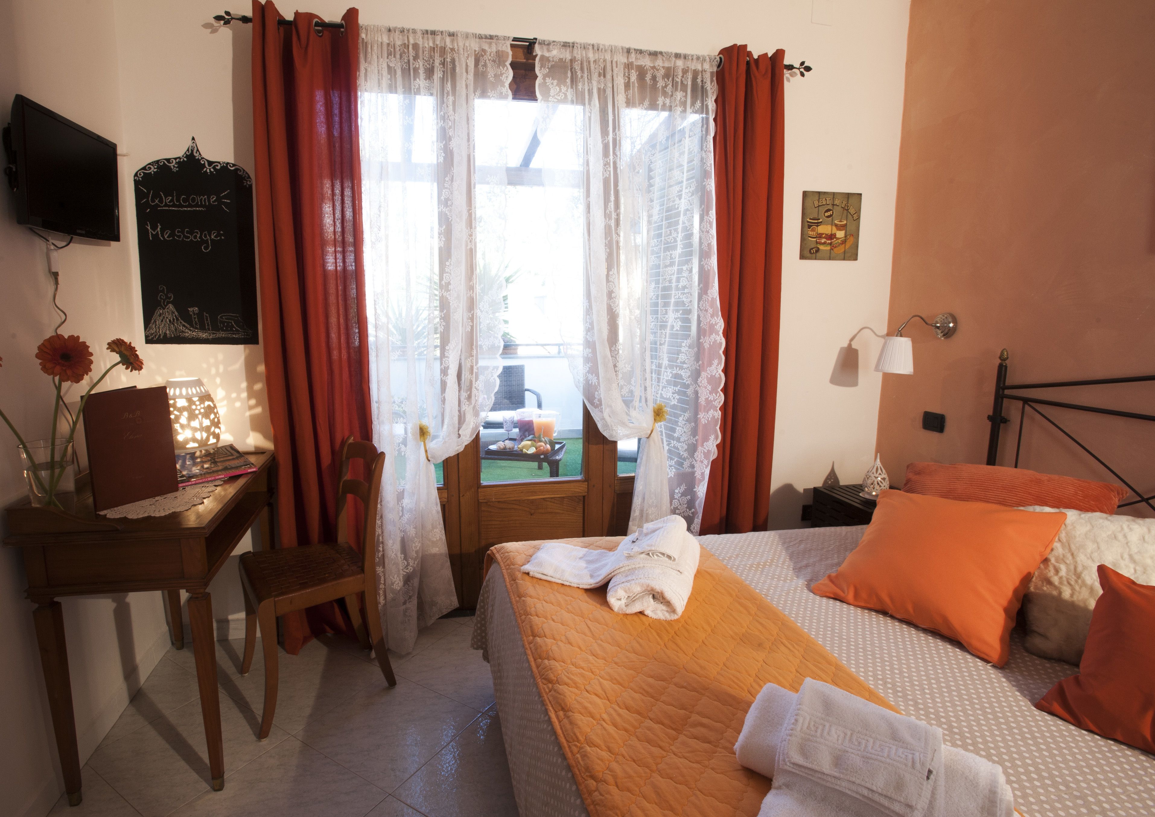 Une chambre à coucher avec un lit, un bureau et une fenêtre avec des rideaux.