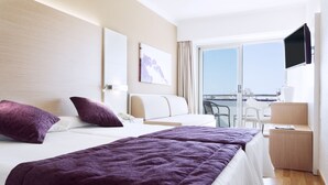 A hotel room with two beds, a TV, a desk, and a balcony with a view. - Mariant (Sant Llorenc des Cardassar)