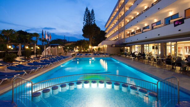A swimming pool with sun loungers and a restaurant area with outdoor seating. - Mariant (Sant Llorenc des Cardassar)