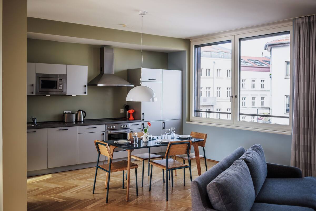 Eine moderne Küche mit Essbereich, großen Fenstern und Blick auf Gebäude.