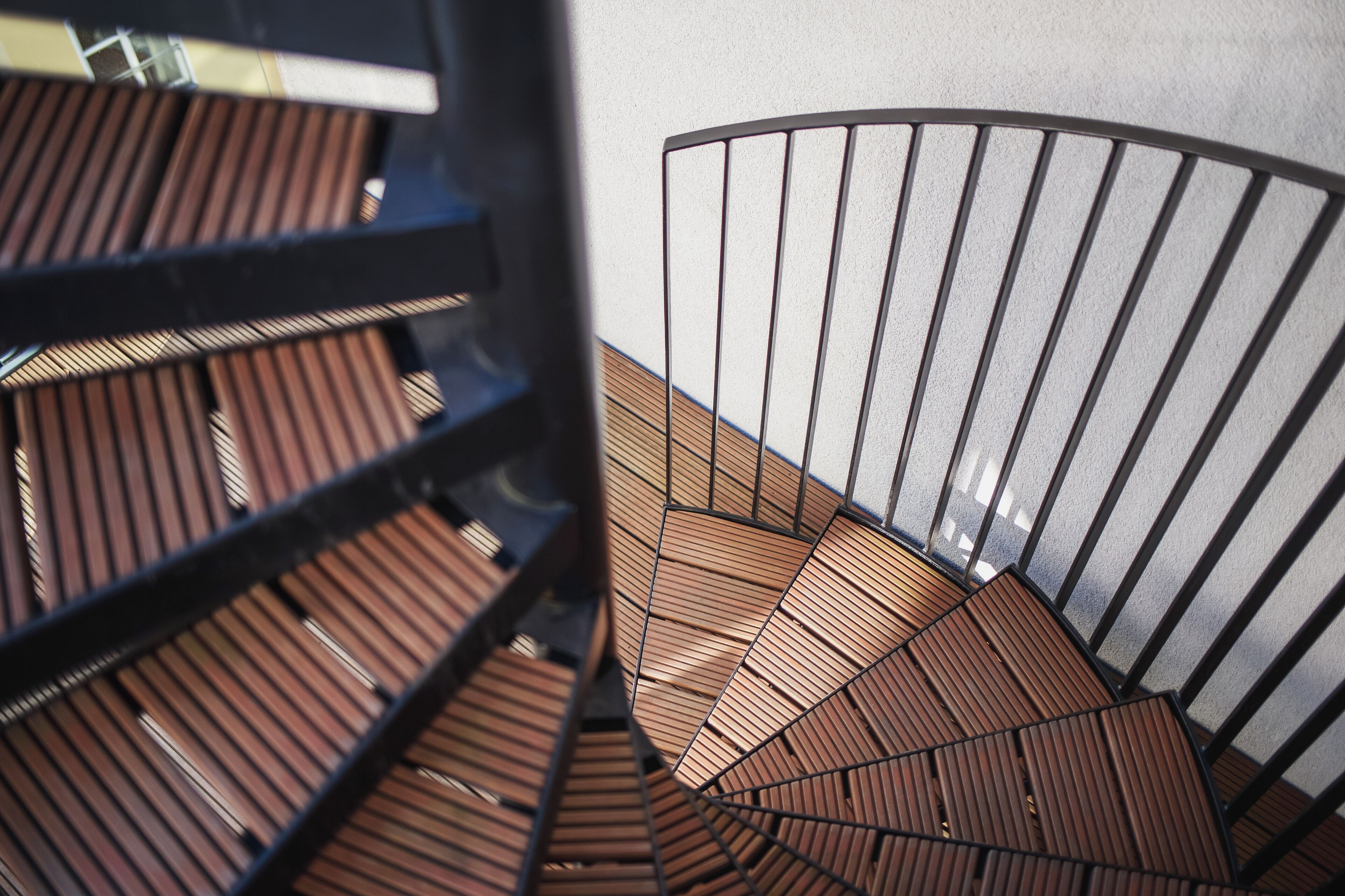 A spiral staircase with wooden steps and metal railings.