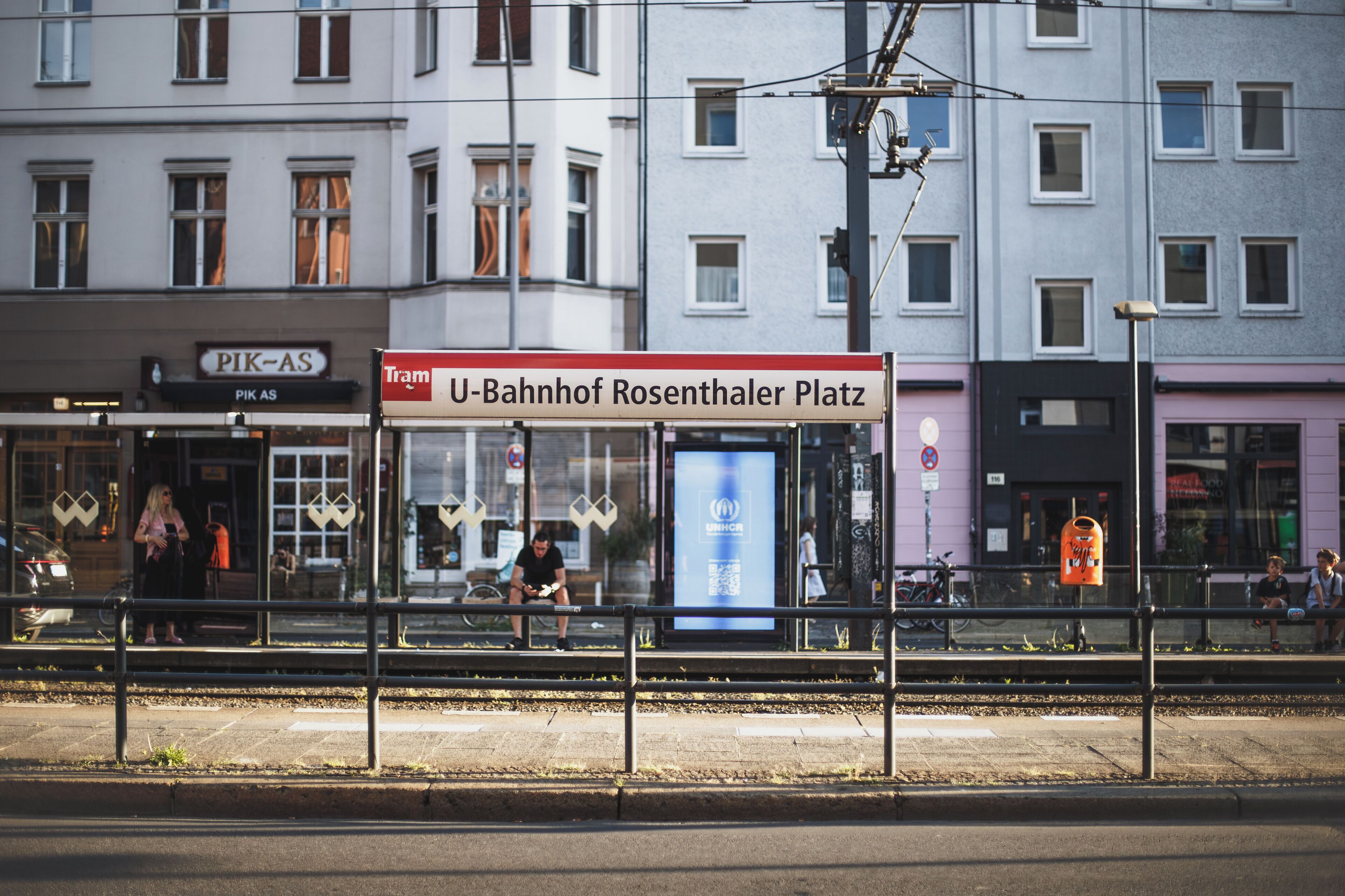 A tram stop with a sign reading "U-Bahnhof Rosenthaler Platz".