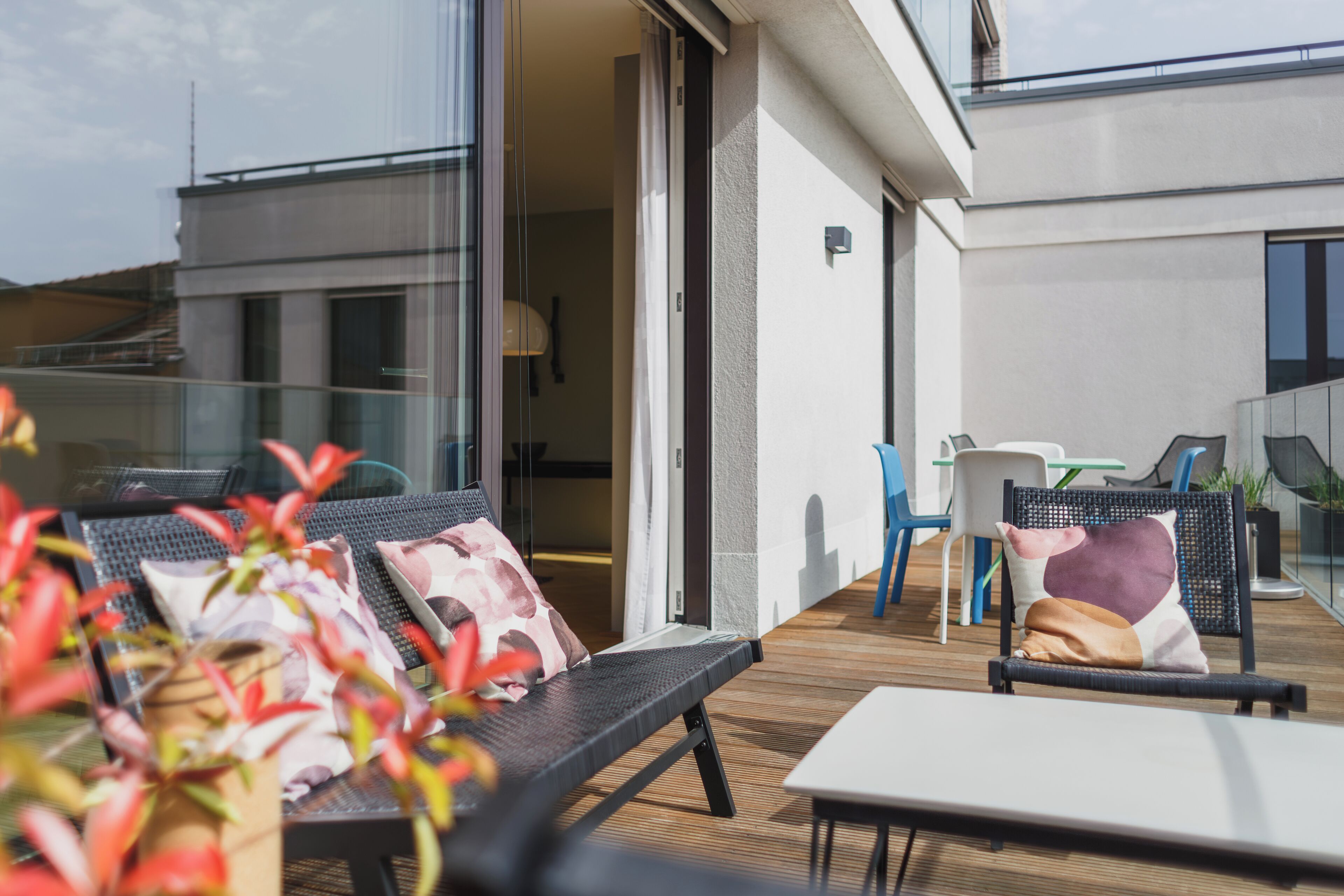 Un área de estar exterior moderna con un sofá, sillas y una mesa.