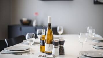 A dining table set with wine bottles, glasses, and salt and pepper shakers.