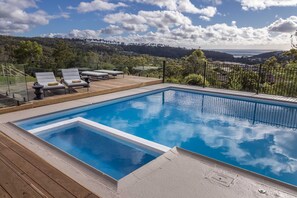 Una piscina al aire libre, sillones reclinables de piscina
