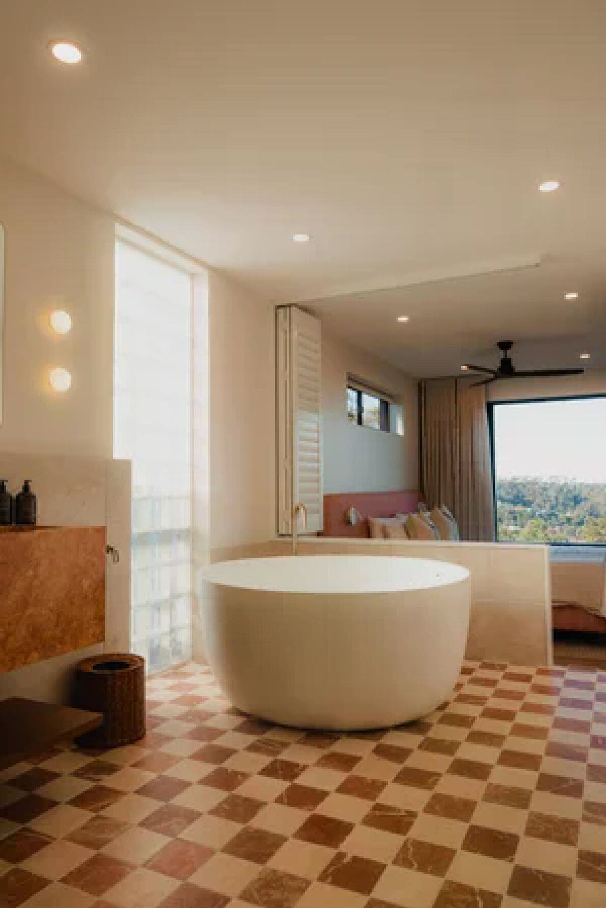 A modern bathroom with a large bathtub, a vanity with a mirror, and a checkered floor.