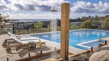 Una piscina al aire libre, sillones reclinables de piscina