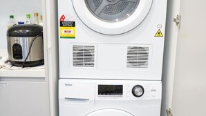 A stacked washer and dryer unit with energy and water efficiency ratings. - De'Vine Escape (Dixons Creek)