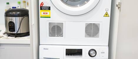 A stacked washer and dryer unit with energy and water efficiency ratings.