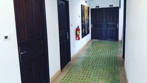 A hallway with dark wooden doors, numbered 304 and 302, and a fire extinguisher mounted on the wall.