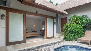 Een moderne villa met een privézwembad, rieten dak en een weelderige tuin.