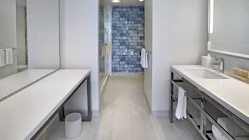 Une salle de bain moderne avec un meuble-lavabo blanc, une cabine de douche en verre et un mur bleu à texture.