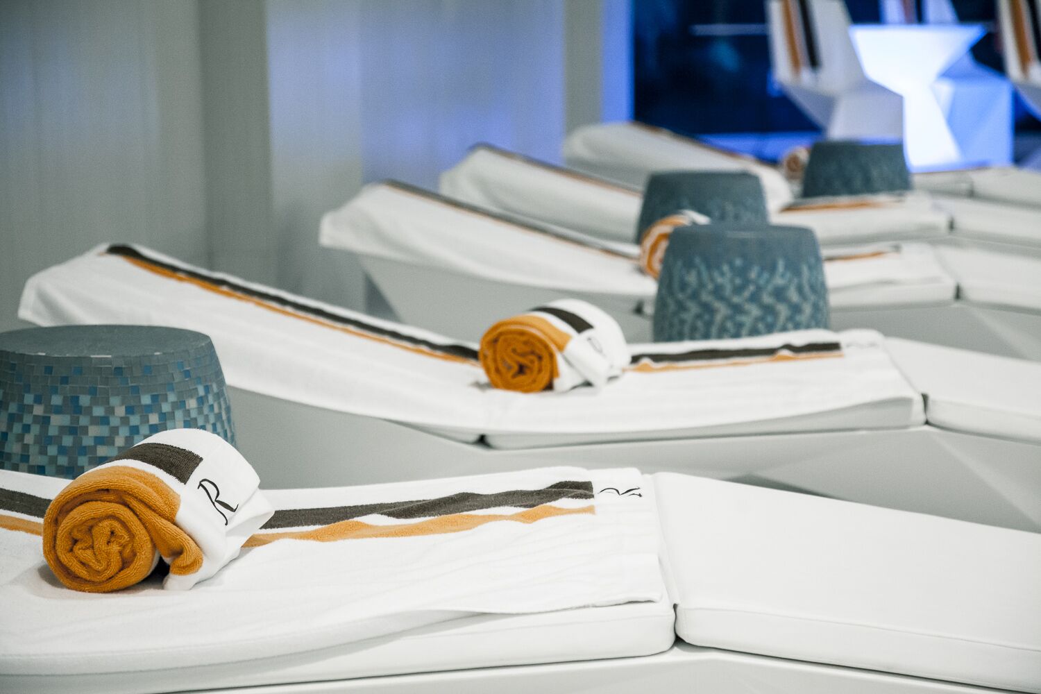 Neatly arranged towels and bathrobes on a hotel room's bed.