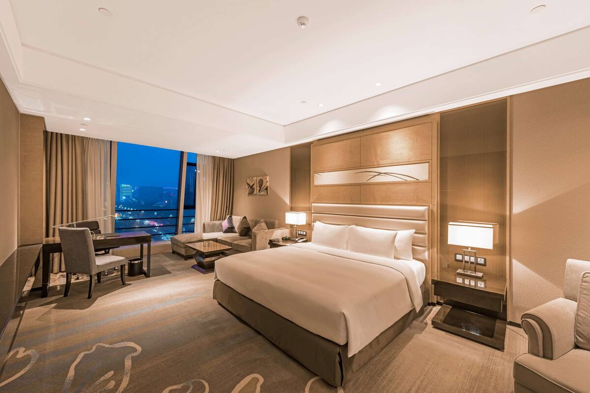 Ein modernes Hotelzimmer mit einem großen Bett, einem Schreibtisch und einer Couch.
