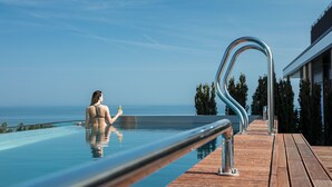 A woman in a swimming pool with a view of the sea.