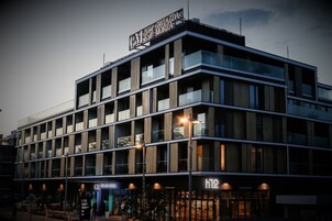 A multi-story hotel with a modern design, featuring balconies and large windows.