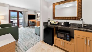 A hotel room with a kitchenette, a desk, a chair, a TV, and a balcony with a view. - Hampton Inn & Suites Lake Placid (Lake Placid)