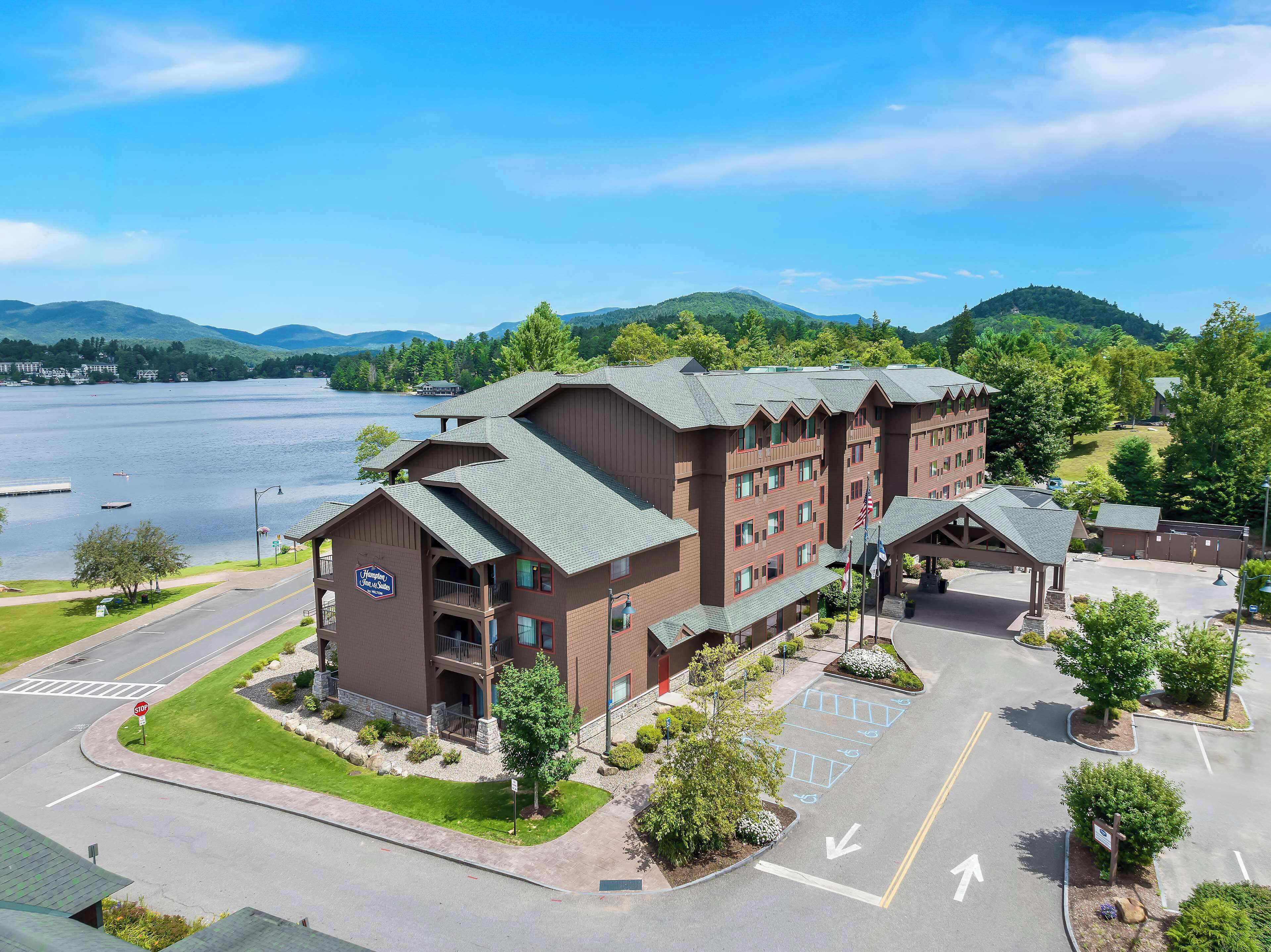 A lodge with a large parking lot, a stop sign, and a view of a lake.