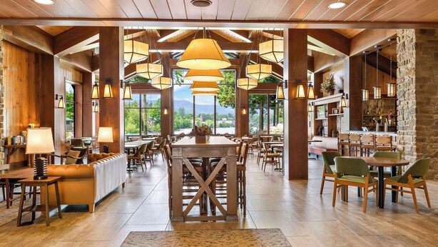 A spacious restaurant with high ceilings, wooden beams, and large windows offering a view of the outdoors. - Hampton Inn & Suites Lake Placid (Lake Placid)
