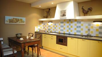 Una cocina con gabinetes amarillos, una mesa de comedor de madera y un salpicadero de azulejos.