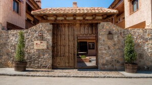Un bâtiment en pierre avec une porte en bois, des plantes en pot et une enseigne indiquant qu’il s’agit d’un hôtel.
