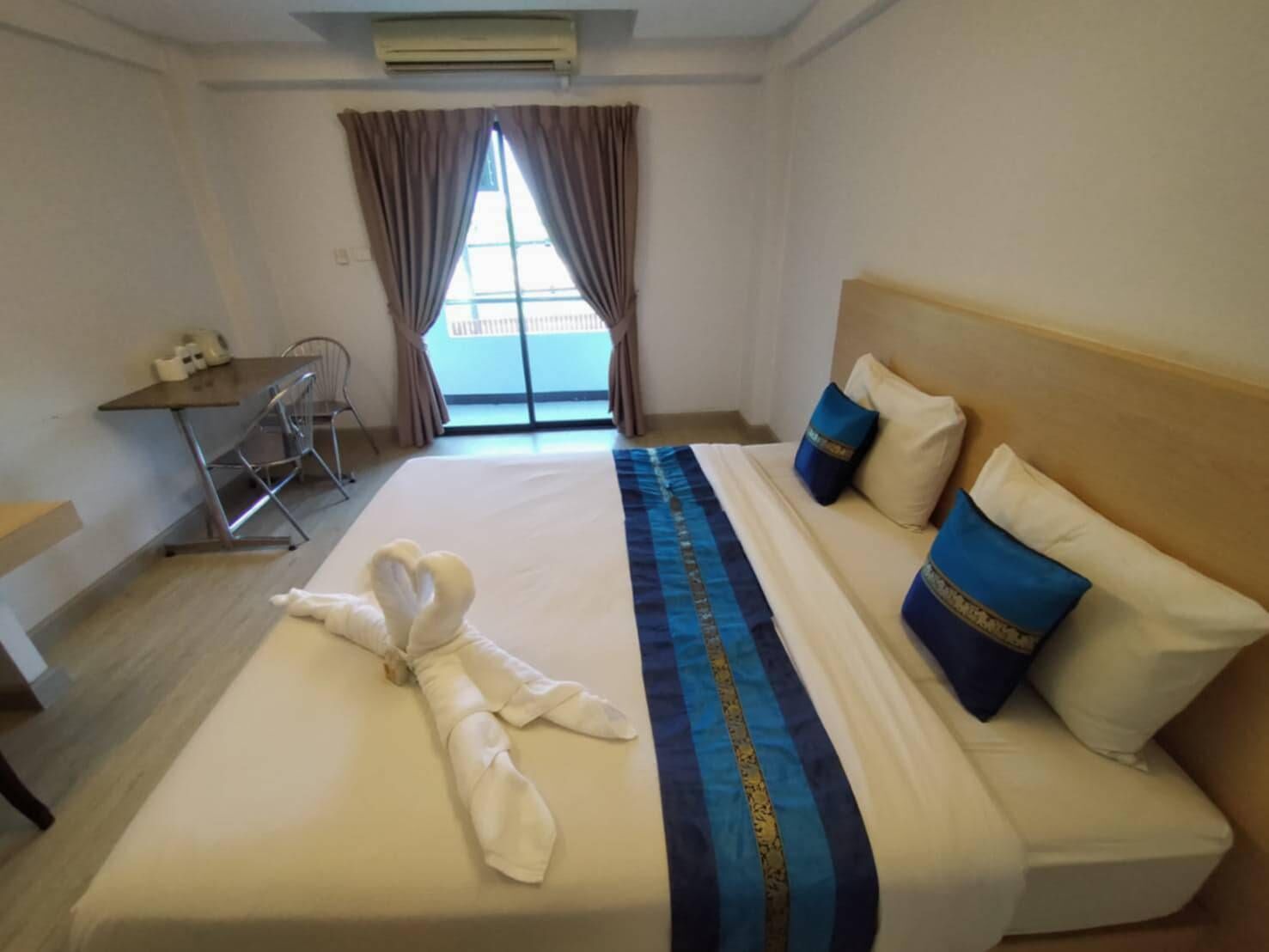 Una habitación de hotel con una cama, un escritorio y una silla.