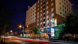 A multi-story hotel with a central courtyard, surrounded by trees and streetlights. - Tara Lake Hotel (Bangkok)