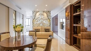 Een modern interieur met een ronde eettafel, een beige bank en een decoratieve wand.