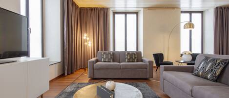 A modern living room with a sofa, a coffee table, and a television.