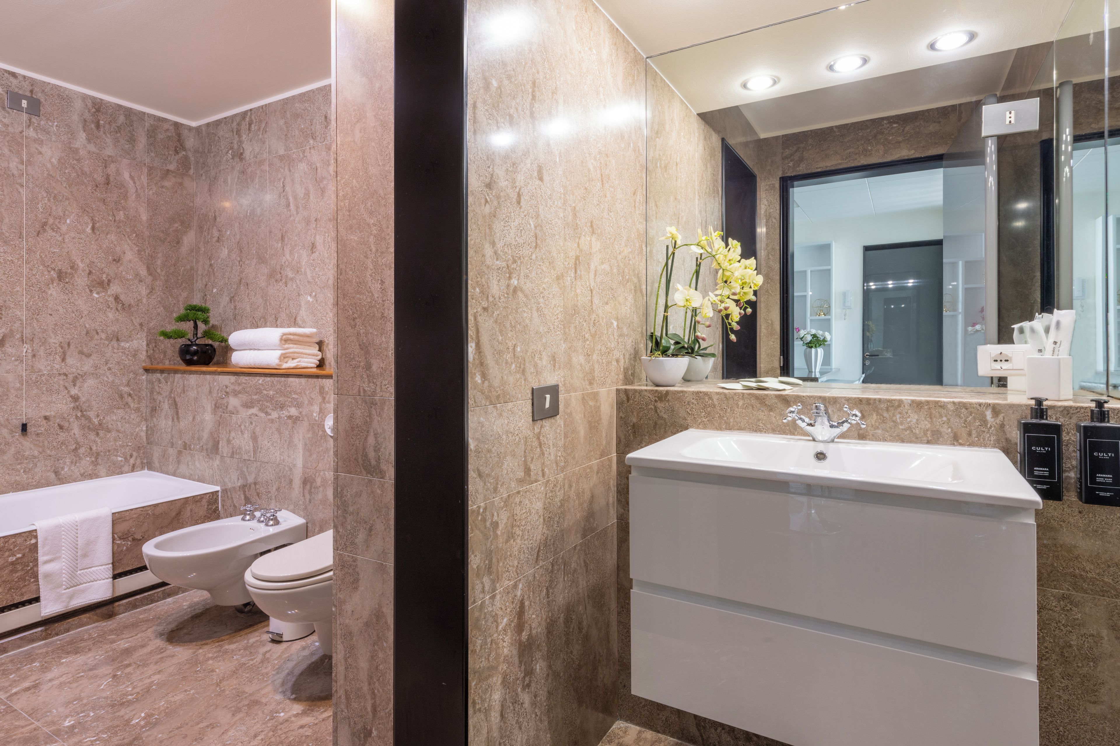 A modern bathroom with a bathtub, a toilet, and a sink.