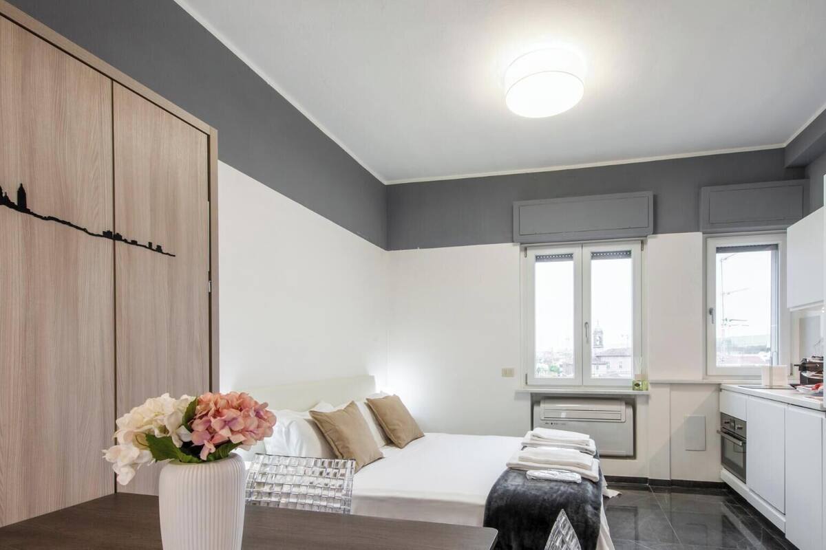 Un apartamento moderno con cama, comedor y cocina.
