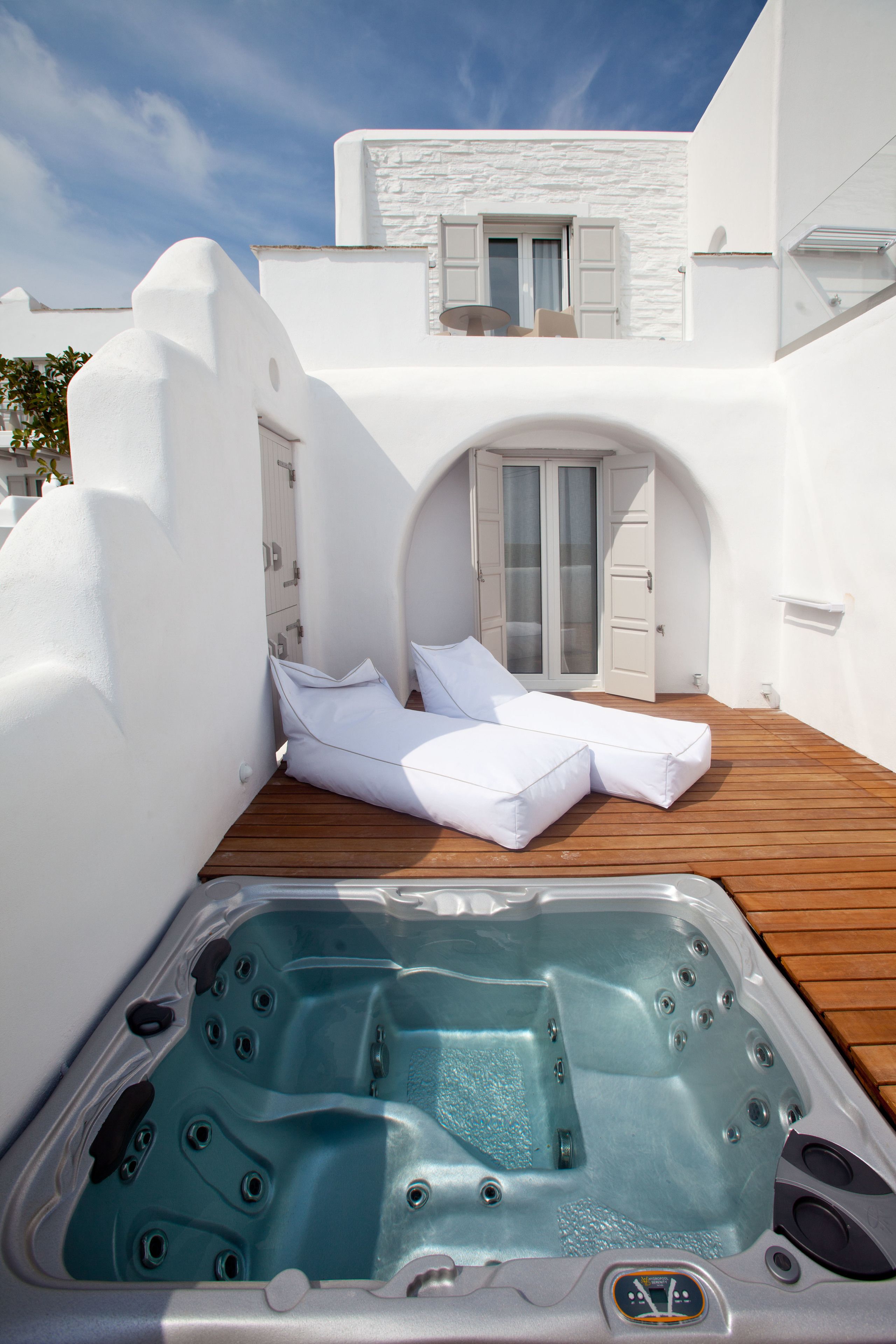 A spa area with a hot tub and a lounge chair.