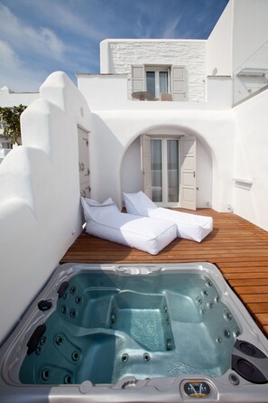 A spa area with a hot tub and a lounge chair. - Golden Sun Hotel (Naxos)