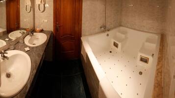 Un baño con dos lavamanos, una puerta de madera y una bañera grande.