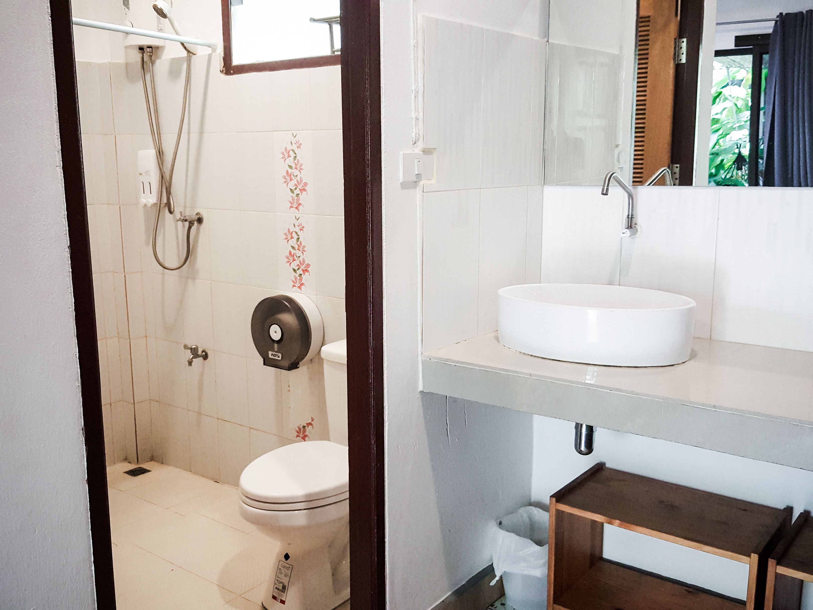 Une salle de bain avec des toilettes, un lavabo et une douche.