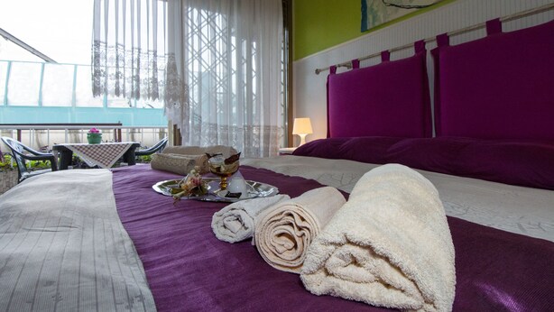 A hotel room with a bed, a table with a tray of toiletries, and a view of the outside. - Passeggiate Romane B&B (Rome)