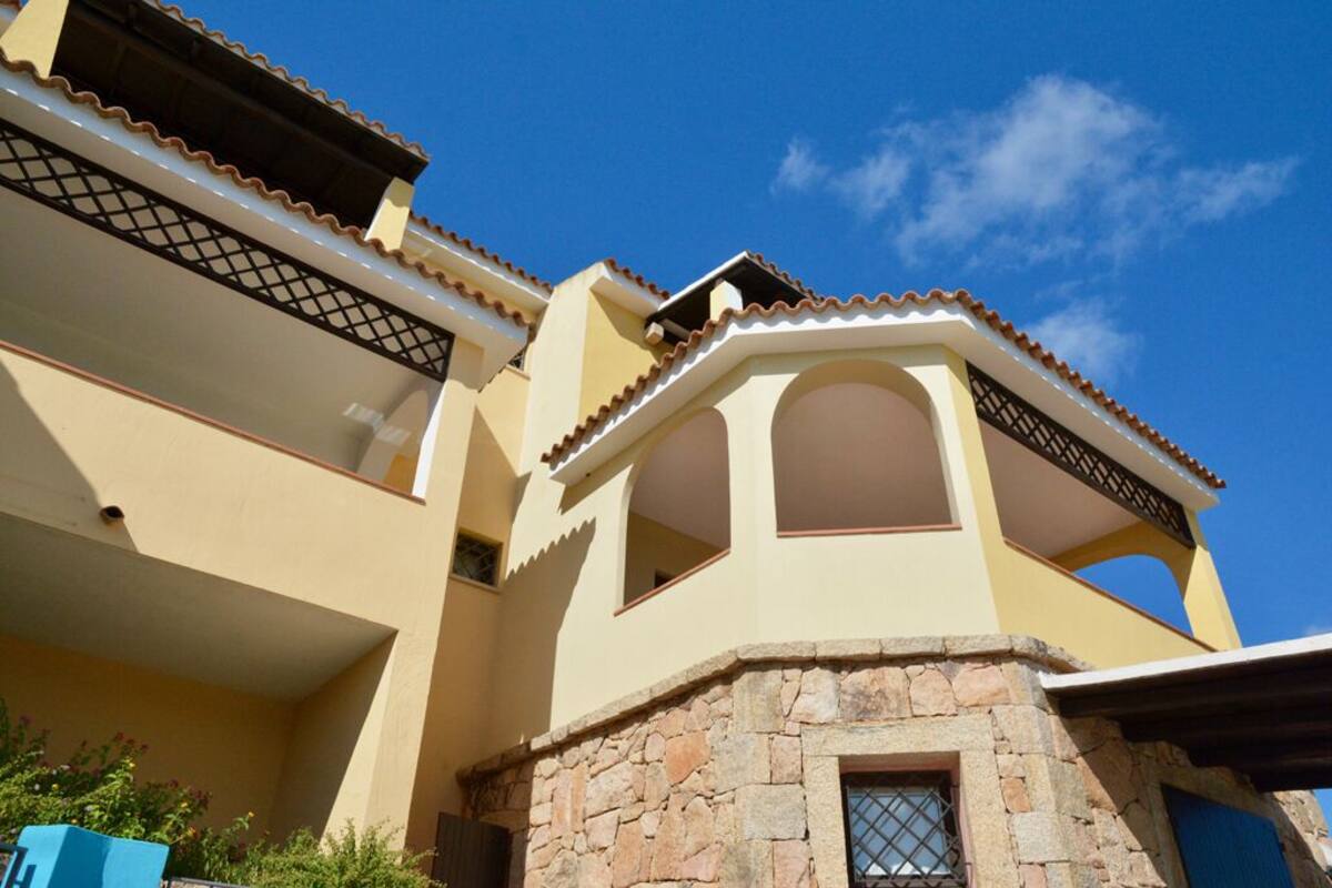 Un bâtiment à deux étages, avec une base en pierre et une façade jaune.