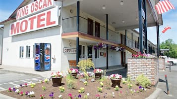 Welcome to the King Oscar Motel, featuring a charming entrance with a covered porch and a small office area.