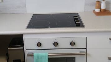 A kitchen with a stainless steel range hood, a built-in oven, and a stovetop.