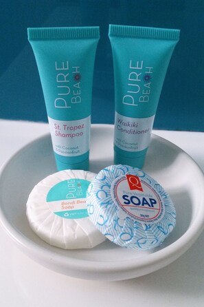 Two bottles of Pure Beach shampoo and conditioner, a soap bar, and a soap bar with a blue pattern. - Karuah Riverside Motel (Karuah)