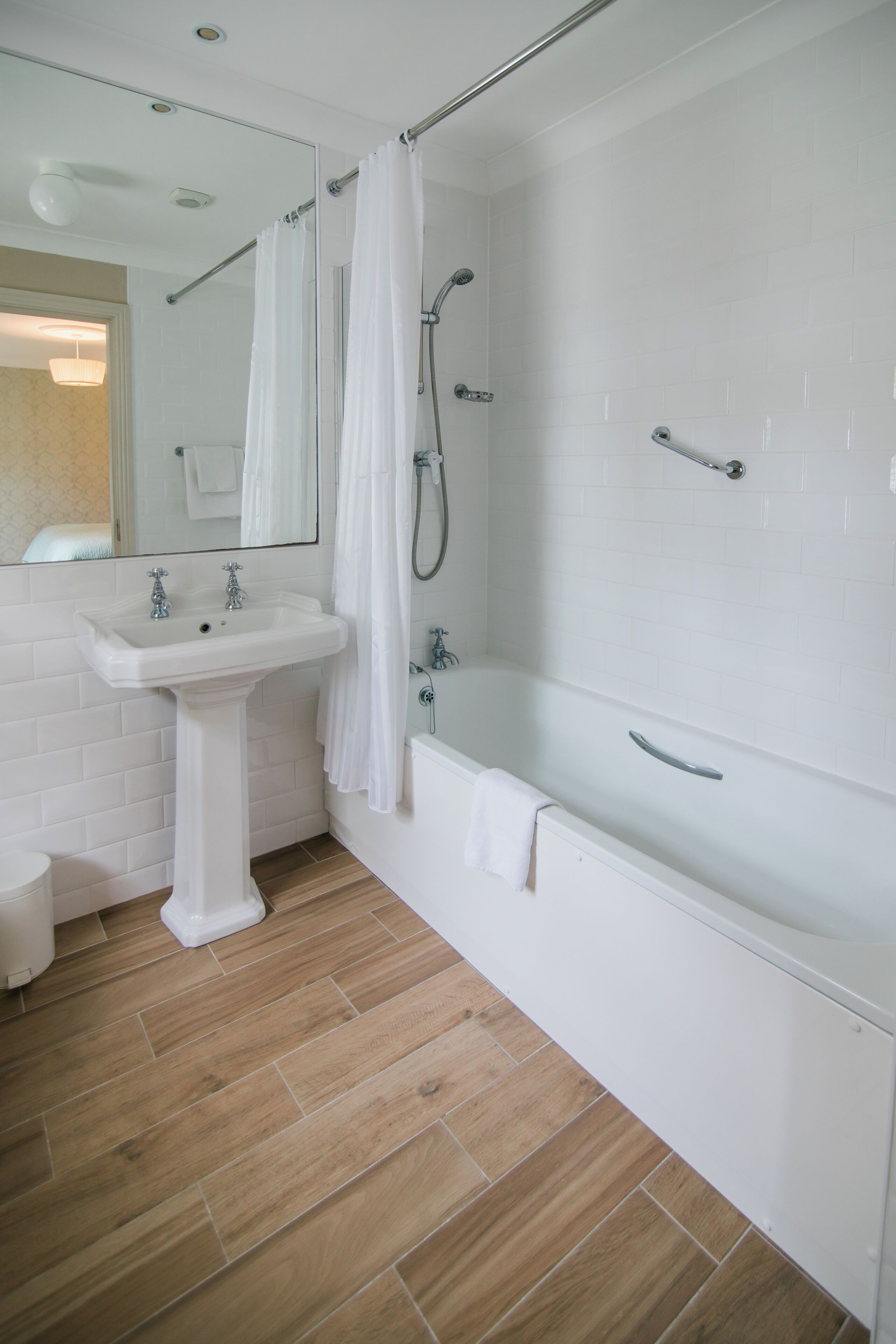 A bathroom with a white sink, a bathtub, and a shower.