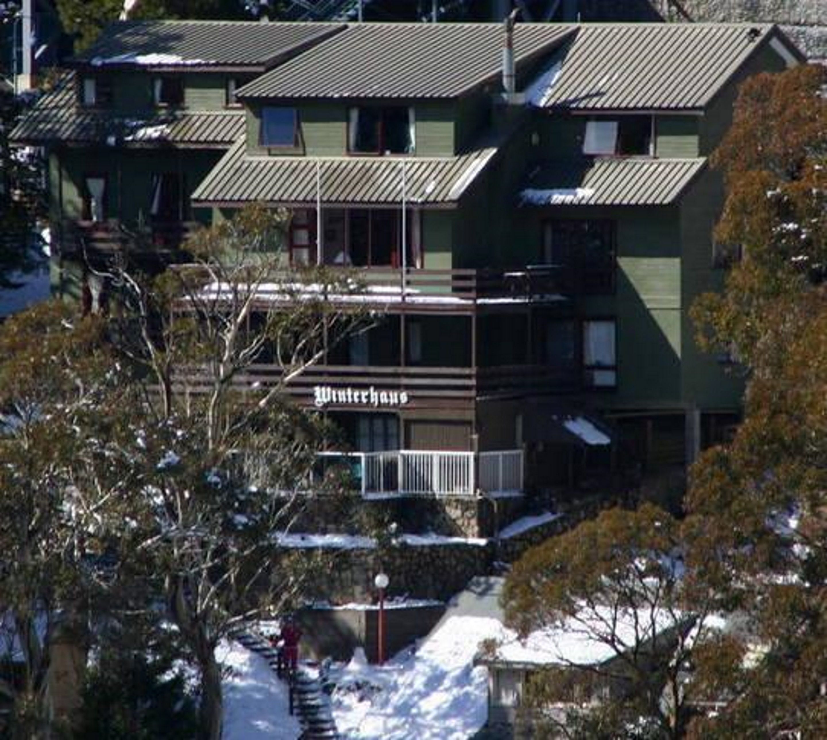 A multi-story building with a green facade and a sign reading "Winterhaus".