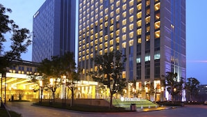 Um edifício de hotel moderno com entrada destacada e fachada bem iluminada.