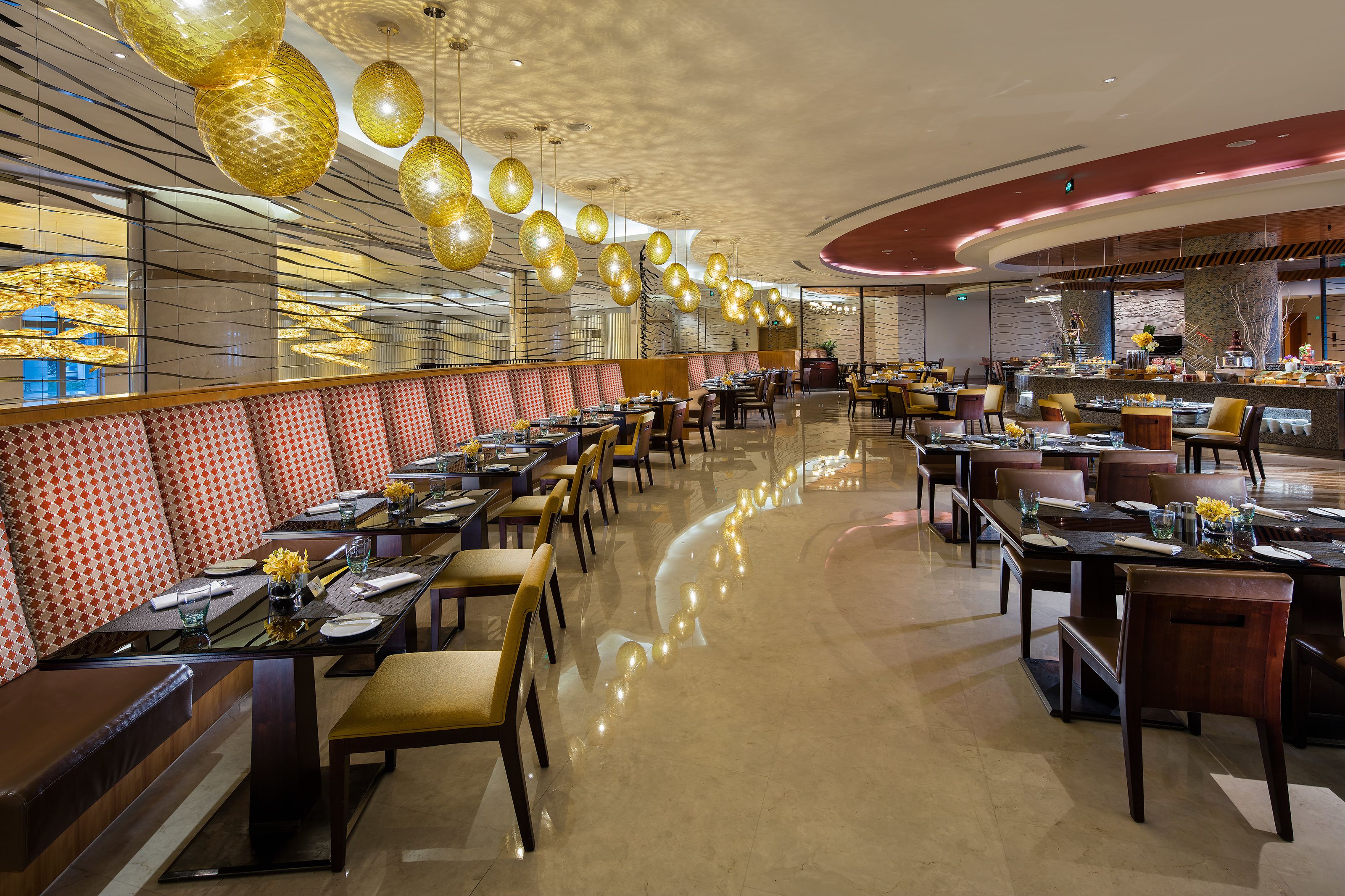 A spacious restaurant with high ceilings, modern lighting, and a variety of seating arrangements.