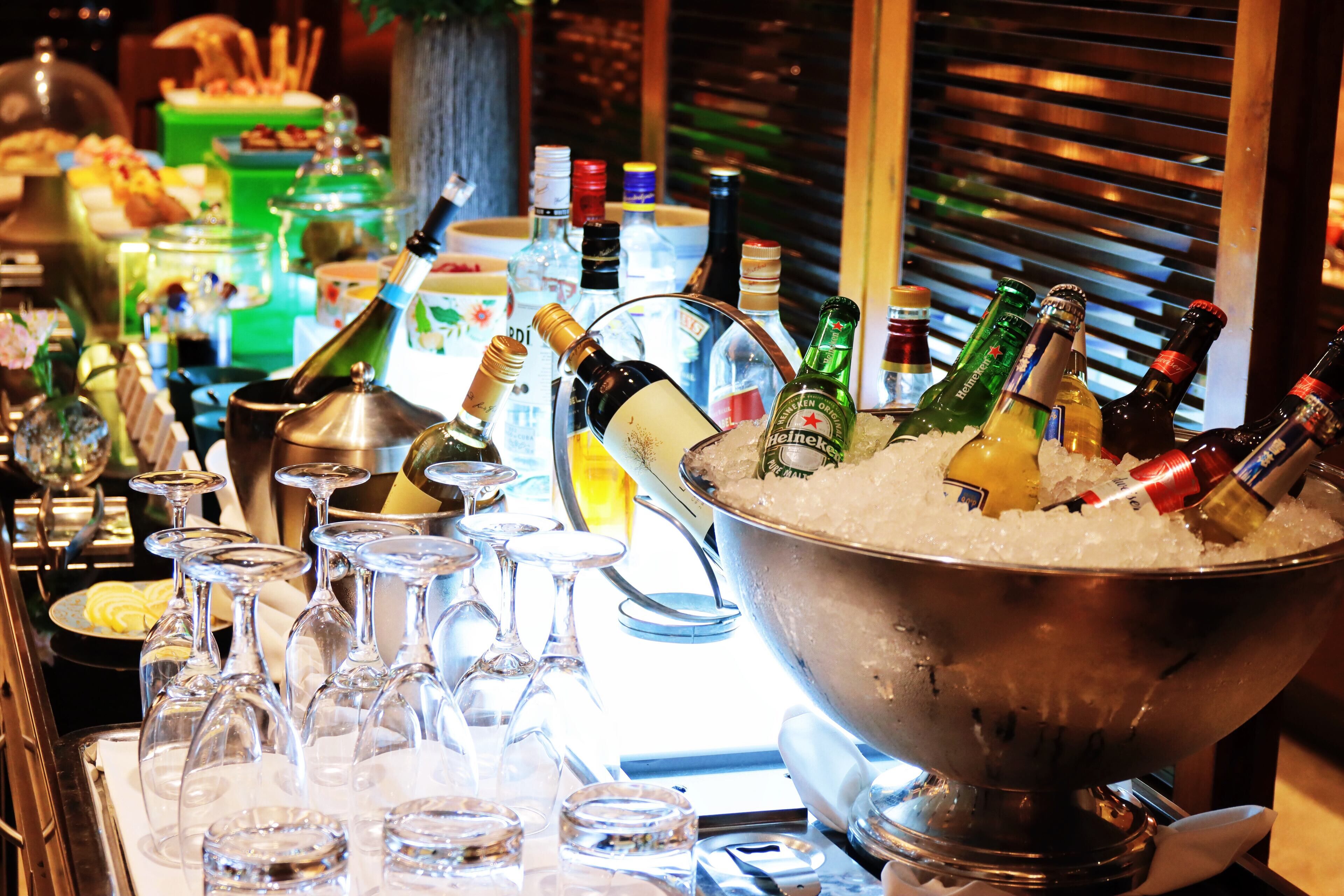 Un espace bar avec un grand seau à glace rempli de bouteilles, de verres et d’une variété de boissons.