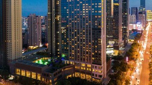 A high-rise building with illuminated signage, surrounded by a busy urban street and other tall buildings. - Shangri-La Shenyang (Shenyang)
